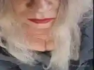 Mature shemale with strong red lipstick teases while smoking seductively